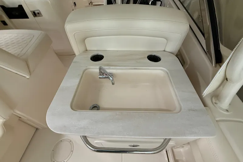 Slide: The Image of Interior of 2026 Grady-White Freedom 275 boat featuring a compact sink and faucet. - 26