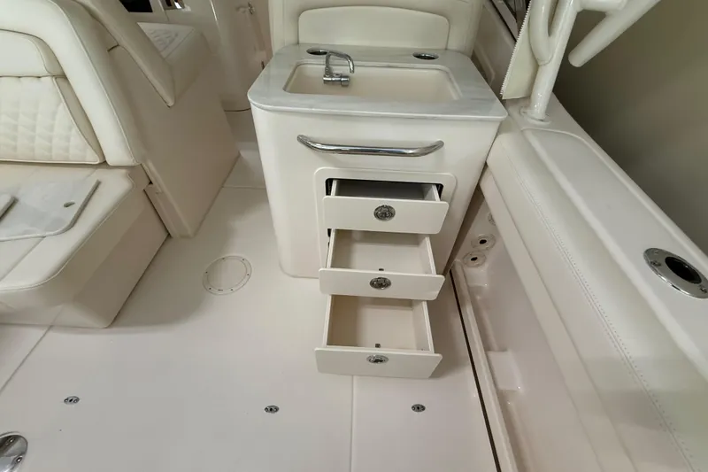 Slide: The Image of Interior of 2026 Grady-White Freedom 275 boat with sink and open storage drawers. - 27