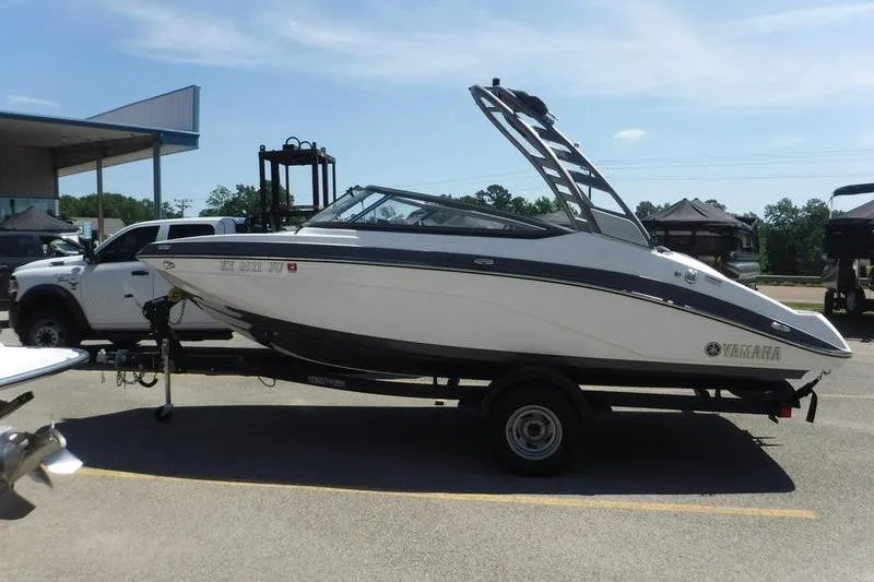 Slide: The Image of 2020 Yamaha Boats 195S on trailer, parked outdoors near a white truck. - 10