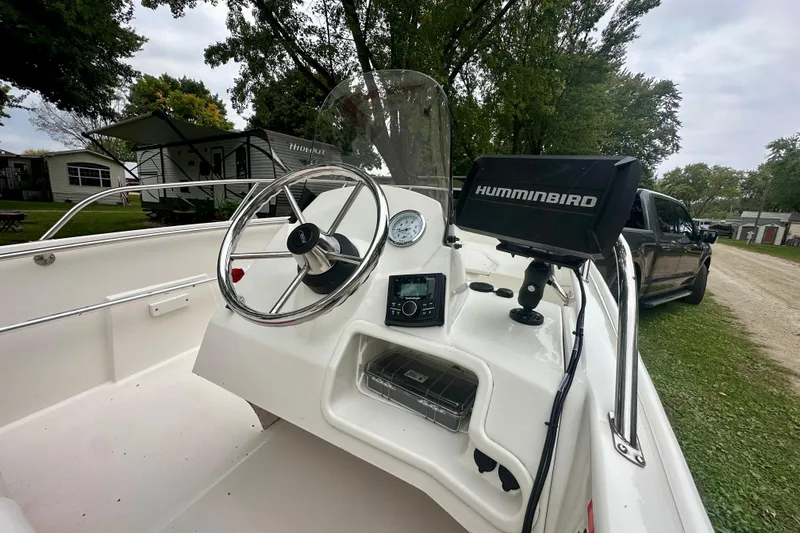 Slide: The Image of 2014 Boston Whaler 150 Super Sport boat dashboard with Humminbird electronics and steering wheel. - 10