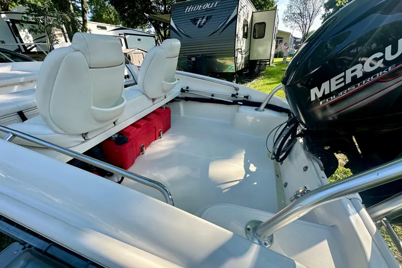 Slide: The Image of 2014 Boston Whaler 150 Super Sport boat interior with Mercury engine and white seating. - 16