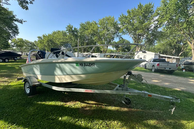 Slide: The Image of 2014 Boston Whaler 150 Super Sport boat on trailer, parked on grass. - 3