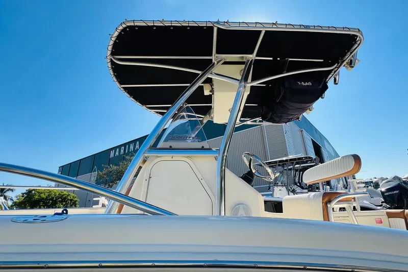 Slide: The Image of 2003 Scout 235 Sportfish boat with T-top, marina background, clear blue sky. - 3
