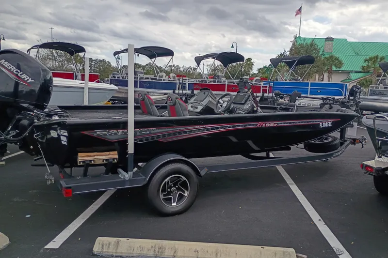 Slide: The Image of 2021 Ranger RT198P boat on trailer in parking lot, overcast sky. - 2