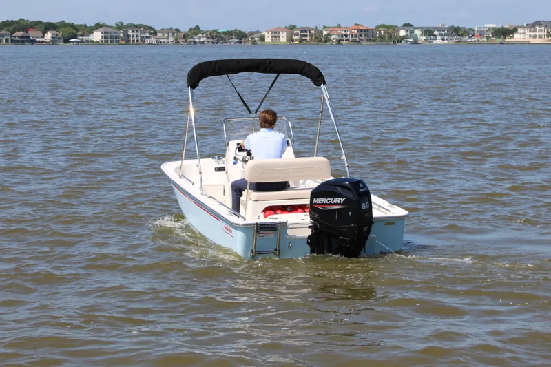 Slide: The Image of Boston Whaler 150 Montauk 2026 on calm water with outboard motor. - 10