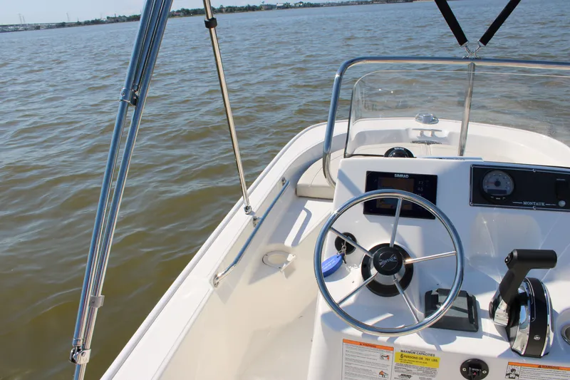 Slide: The Image of Boston Whaler 150 Montauk 2026 helm on open water. - 20