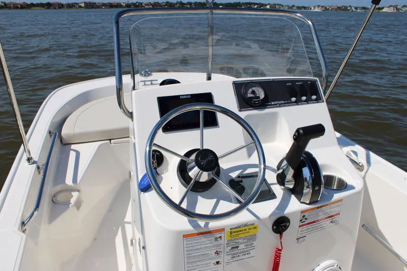 Slide: The Image of Boston Whaler 150 Montauk 2026 helm console on the water. - 23
