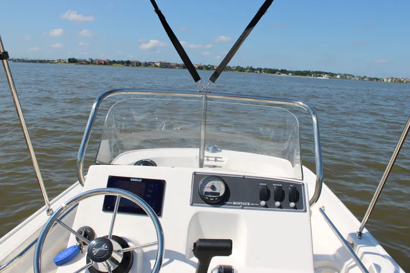 Slide: The Image of Interior view of 2026 Boston Whaler 150 Montauk on the water. - 24
