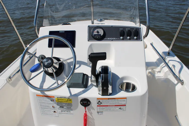 Slide: The Image of Boston Whaler 150 Montauk 2026 helm console on the water. - 25
