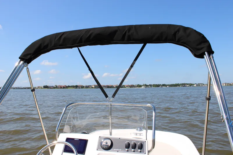 Slide: The Image of Boston Whaler 150 Montauk 2026 on calm waters with Bimini top. - 27