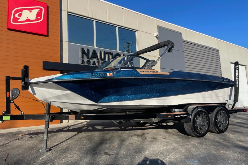 Slide: The Image of 2023 Nautique Ski Nautique boat on trailer outside dealership. - 2