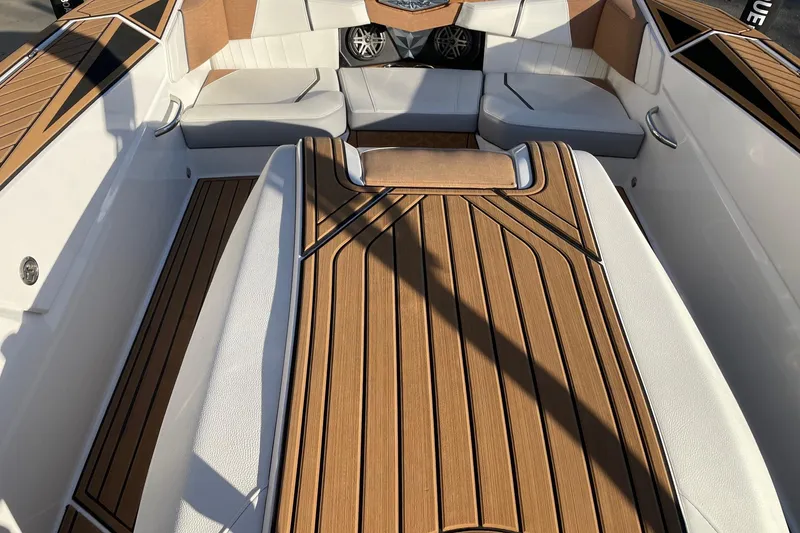 Slide: The Image of 2023 Nautique Ski Nautique interior with teak flooring and cushioned seating. - 7