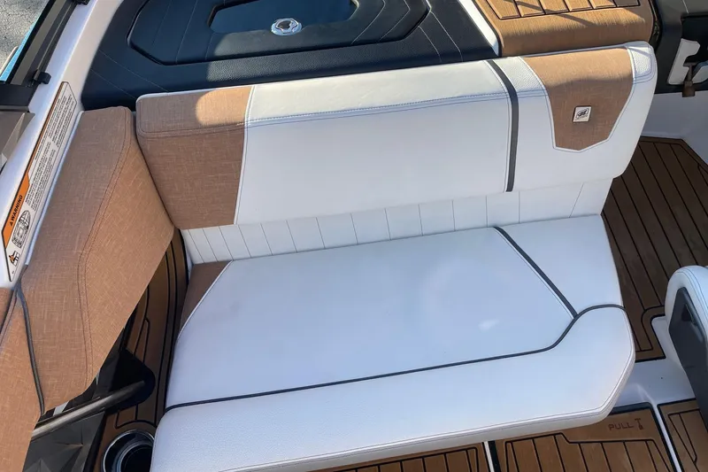 Slide: The Image of 2023 Nautique Ski Nautique boat interior with white and tan seating, teak flooring. - 9
