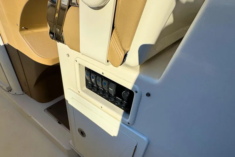 Slide: The Image of Control panel on a 2020 Sailfish 360 CC boat, featuring switches and beige seating. - 29