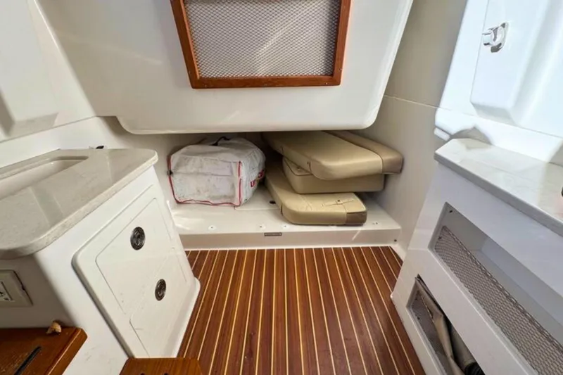 Slide: The Image of 2020 Sailfish 360 CC cabin interior with storage and seating, featuring wood flooring. - 33
