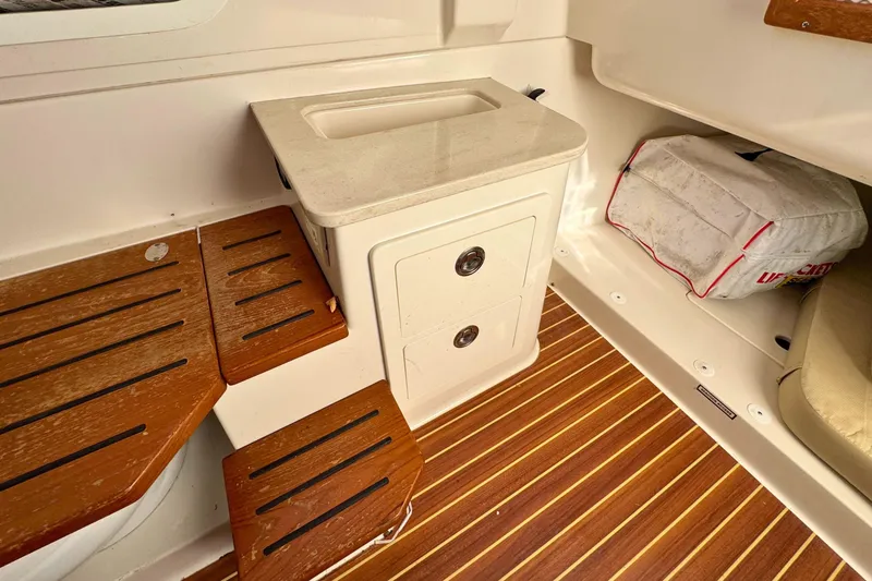 Slide: The Image of 2020 Sailfish 360 CC interior with wooden steps, storage, and cushioned seating. - 34