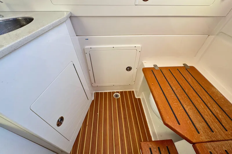 Slide: The Image of 2020 Sailfish 360 CC interior with wooden flooring and compact storage. - 36