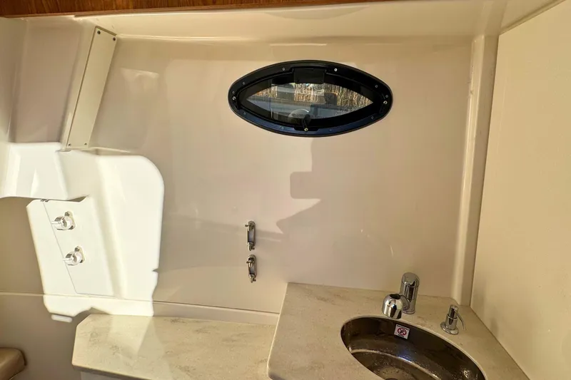 Slide: The Image of Interior of 2020 Sailfish 360 CC boat featuring a compact sink and porthole window. - 40