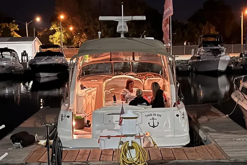 Slide: The Image of 2000 Sea Ray 340 Sundancer docked at night with people relaxing inside. - 12