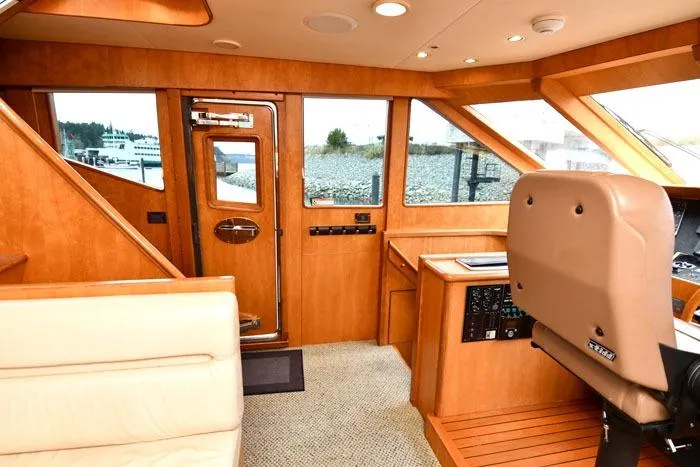 Slide: The Image of Interior of a 2001 Symbol Raised Pilothouse Motoryacht with wood paneling and helm station. - 19