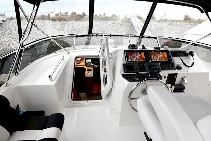 Slide: The Image of Raised pilothouse of 2001 Symbol Motoryacht with navigation equipment and white seating. - 23