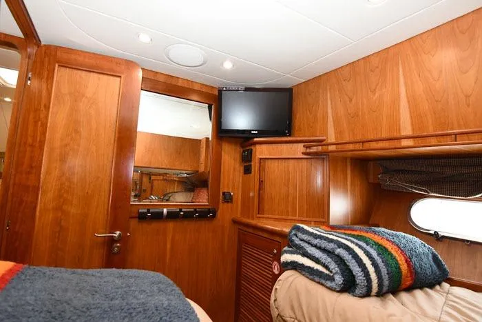 Slide: The Image of Luxurious 2001 Symbol Raised Pilothouse Motoryacht cabin with wood paneling and cozy bedding. - 35