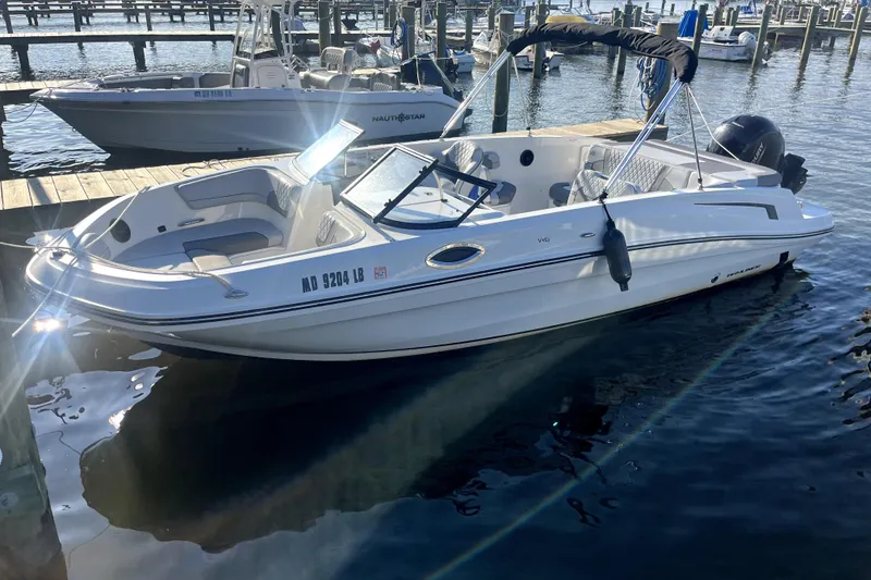 The Image of 2023 Bayliner VR6 Bowrider OB docked at marina, sunlight reflecting on water. - 1