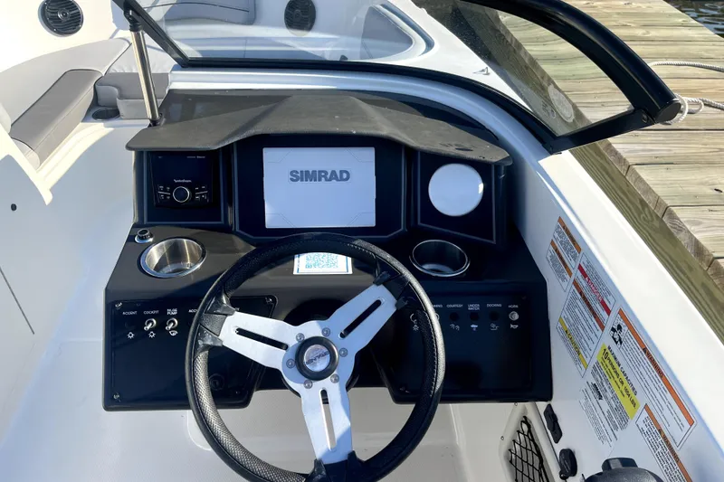 Slide: The Image of 2023 Bayliner VR6 Bowrider OB dashboard with steering wheel and Simrad display. - 5