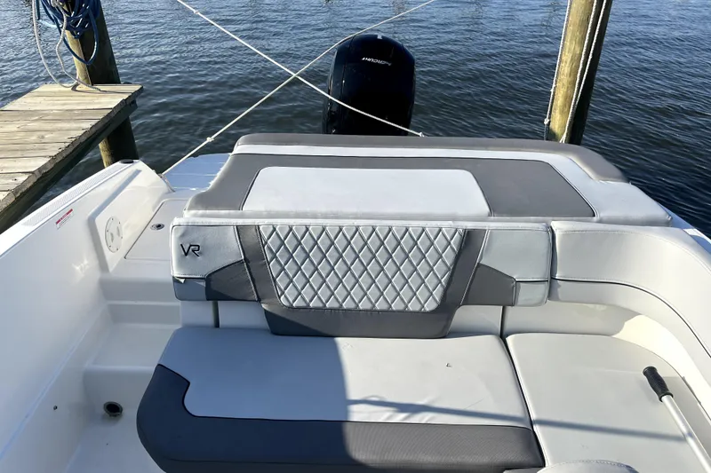 Slide: The Image of 2023 Bayliner VR6 Bowrider OB boat interior with cushioned seating and water view. - 7