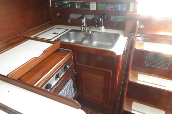Slide: The Image of 1979 Tartan T 37 yacht kitchen with wooden cabinetry, dual sink, and stove. - 18