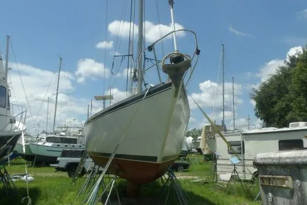 Slide: The Image of 1979 Tartan T 37 sailboat on stands in a boatyard under a blue sky. - 37