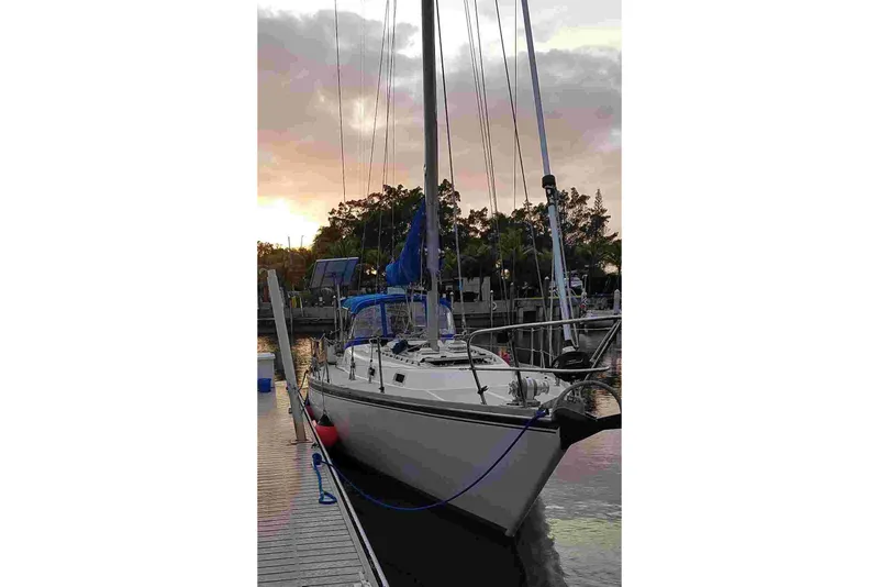 Slide: The Image of Sailboat Tartan T 37, 1979 model, docked at sunset with vibrant sky. - 2