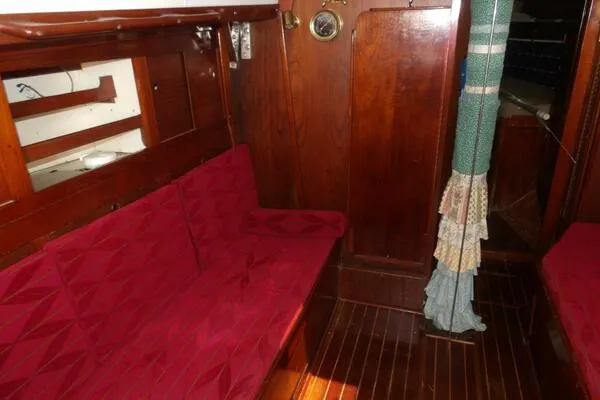 Slide: The Image of Interior of 1979 Tartan T 37 sailboat with red cushioned seating and wooden paneling. - 22