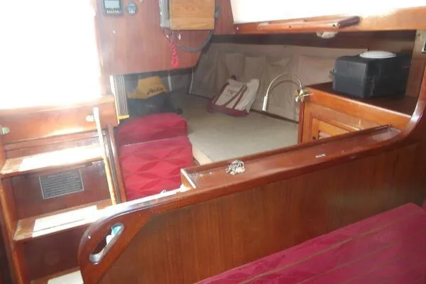 Slide: The Image of Interior of a 1979 Tartan T 37 sailboat with wooden furnishings and red cushions. - 23