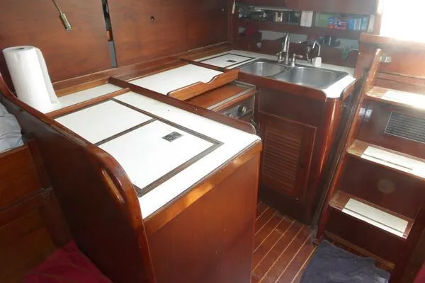 Slide: The Image of 1979 Tartan T 37 yacht interior with wooden cabinetry and compact kitchen area. - 26
