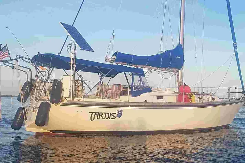 Slide: The Image of 1979 Tartan T 37 sailboat with blue canopy and solar panel on calm water. - 3