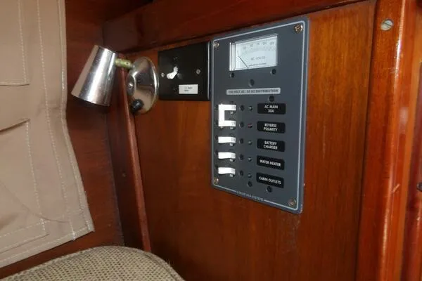 Slide: The Image of 1979 Tartan T 37 yacht electrical panel with switches and meter on wooden interior. - 34