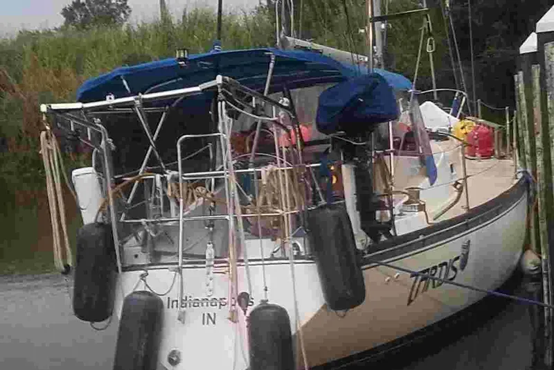 Slide: The Image of 1979 Tartan T 37 sailboat docked, featuring blue canopy and equipment on deck. - 4
