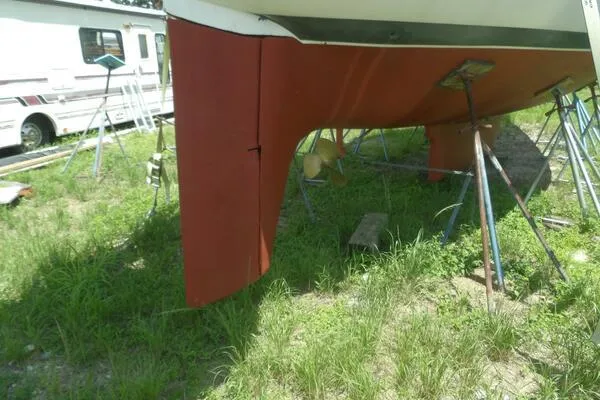 Slide: The Image of 1979 Tartan T 37 sailboat hull on stands, grassy outdoor setting. - 41