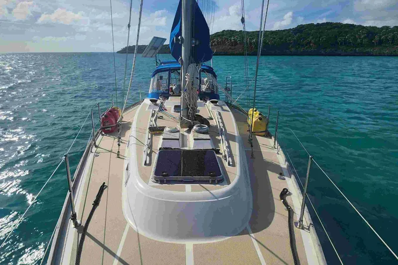 Slide: The Image of 1979 Tartan T 37 sailboat on calm blue waters, scenic coastal view. - 7