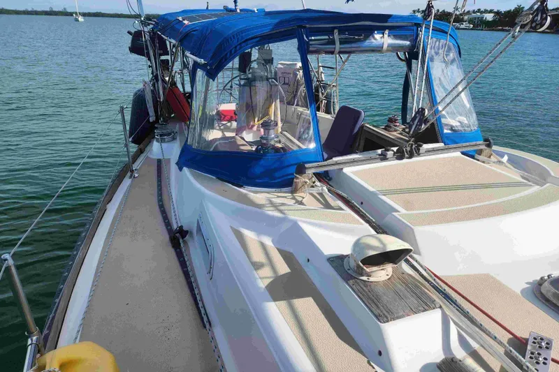 Slide: The Image of 1979 Tartan T 37 sailboat with blue canopy, docked on calm water. - 9
