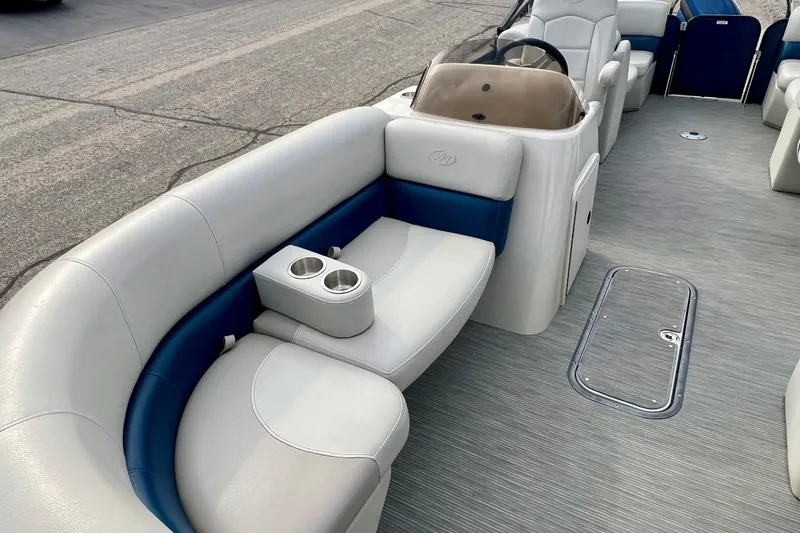 Slide: The Image of 2018 Manitou 23 Aurora LE pontoon boat interior with plush seating and cup holders. - 13