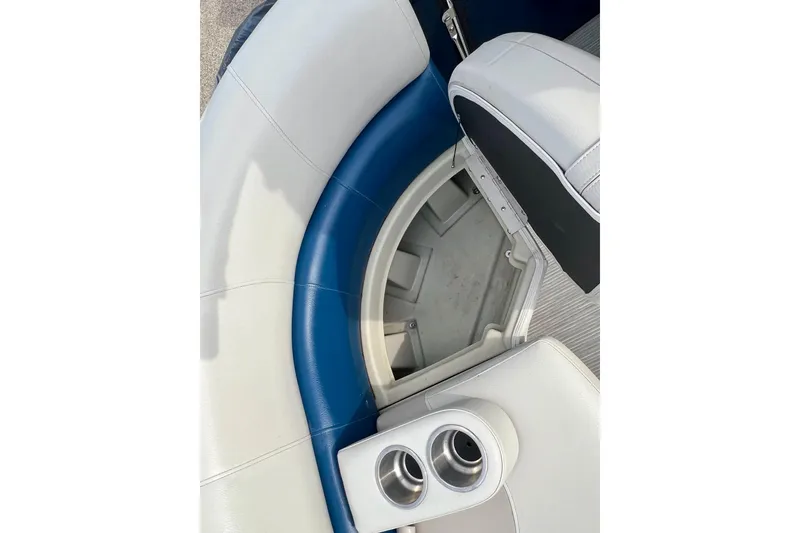 Slide: The Image of 2018 Manitou 23 Aurora LE boat interior with blue and white seating and cup holders. - 17