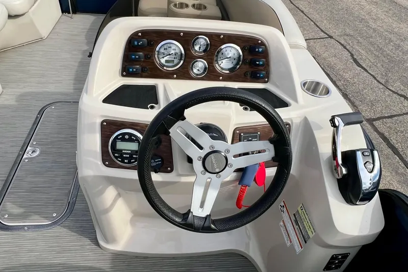 Slide: The Image of 2018 Manitou 23 Aurora LE boat dashboard with steering wheel and control panel. - 21