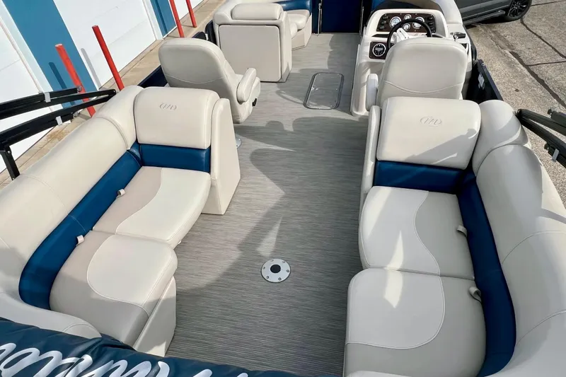 Slide: The Image of 2018 Manitou 23 Aurora LE pontoon boat interior with beige and blue seating. - 30
