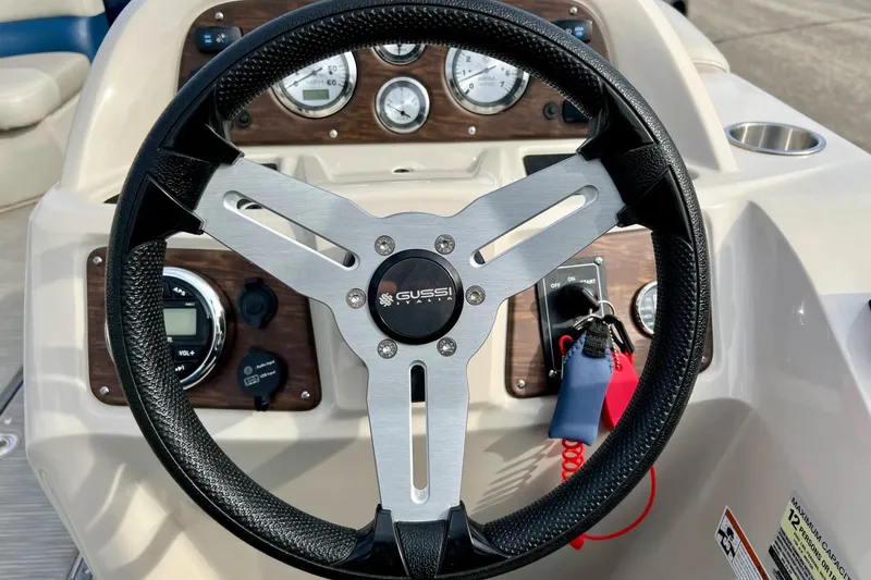 Slide: The Image of Steering wheel of 2018 Manitou 23 Aurora LE boat with dashboard controls. - 50