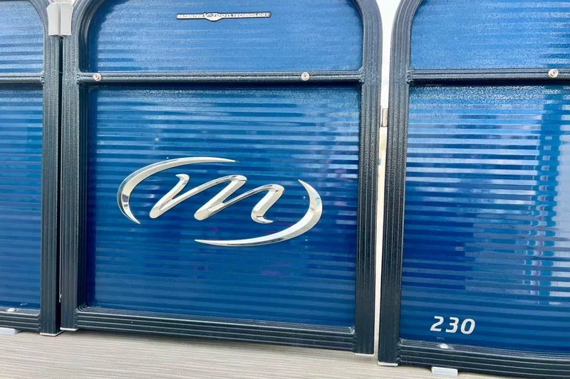 Slide: The Image of 2018 Manitou 23 Aurora LE boat with blue paneling and logo detail. - 8