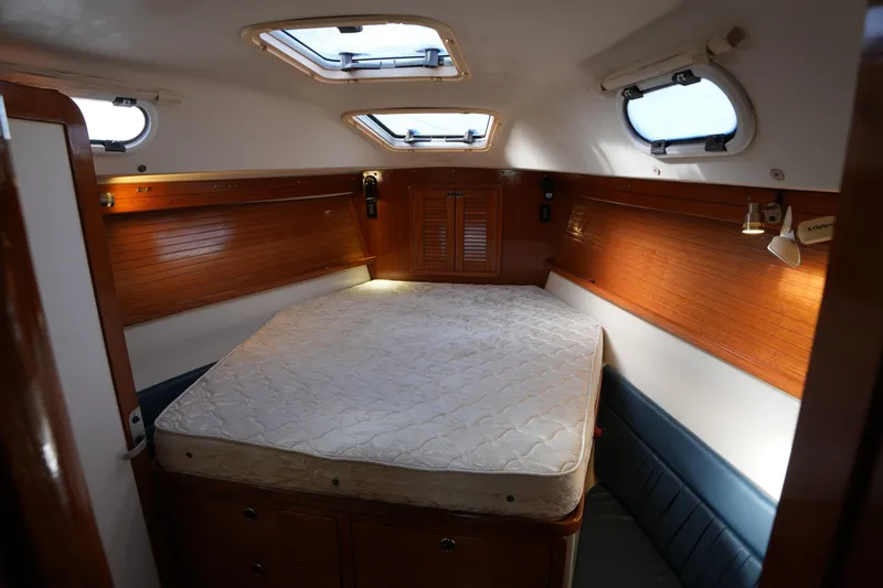 Slide: The Image of Interior cabin of 2002 Catalina 42 Mark II sailboat with bed and wooden paneling. - 13