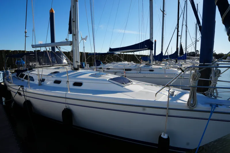 Slide: The Image of 2002 Catalina 42 Mark II sailboat docked in a marina under clear blue skies. - 4