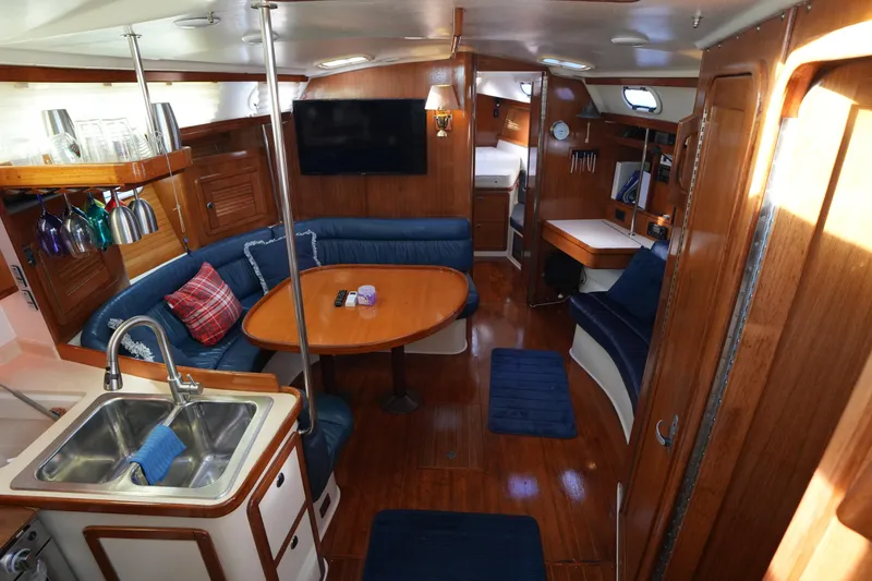 Slide: The Image of Interior of a 2002 Catalina 42 Mark II sailboat with wood finish and blue seating. - 12